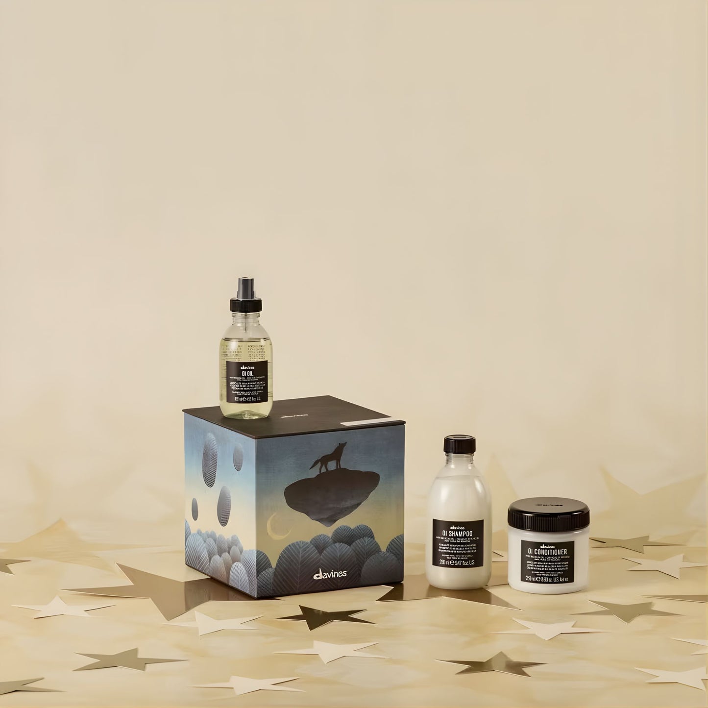 Aveda products including a bottle, box, and jar on a beige surface with a minimal background.