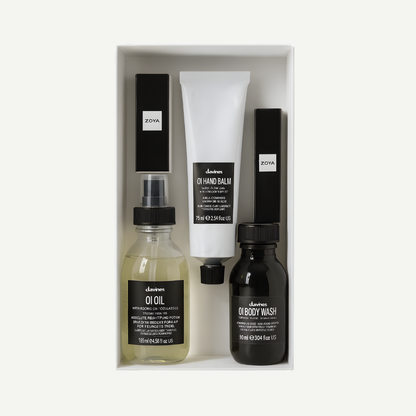 Set of skincare products including Davines OI oil, Davines OI balm, and Davines body wash in a box on a white background